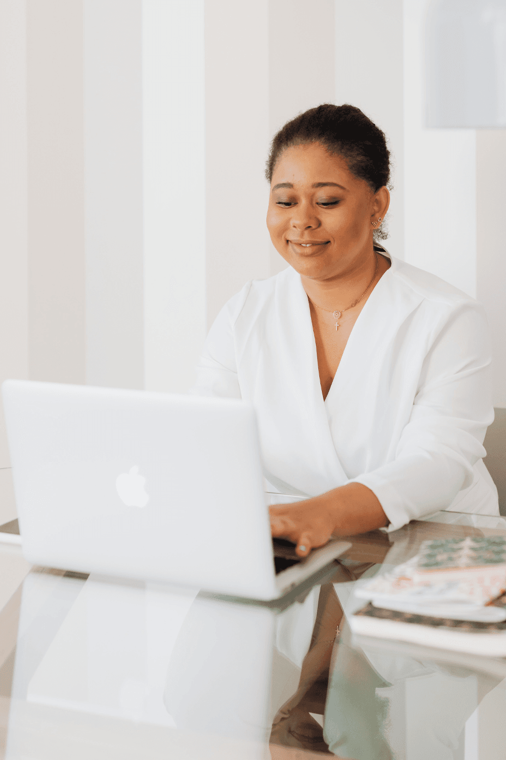 Woman smiling and typing on a laptop